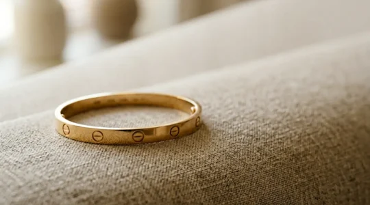 Nahaufnahme eines ikonischen Luxusarmbands mit charakteristischen Schrauben auf elegantem Hintergrund