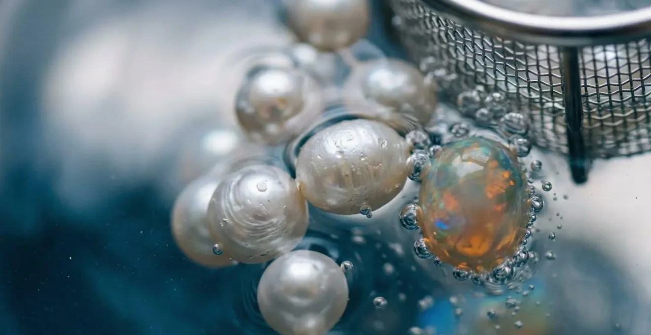 Nahaufnahme eines Ultraschallbads mit empfindlichen Edelsteinen und Wasserbewegung