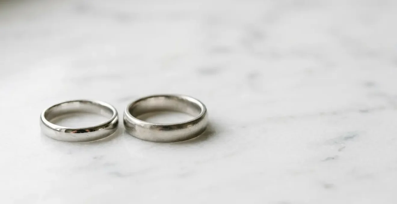 Nahaufnahme von rhodiniertem Weißgold- und Platinring nebeneinander auf neutralem Hintergrund, die den Unterschied zwischen beiden weißen Edelmetallen für Allergiker zeigt