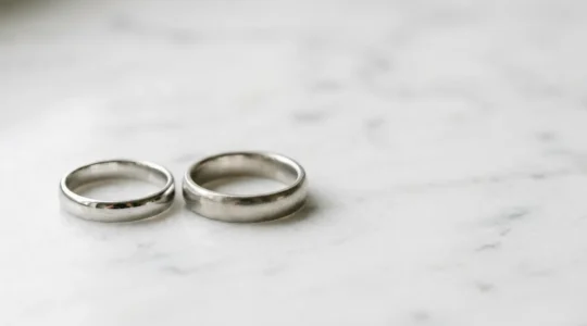 Nahaufnahme von rhodiniertem Weißgold- und Platinring nebeneinander auf neutralem Hintergrund, die den Unterschied zwischen beiden weißen Edelmetallen für Allergiker zeigt